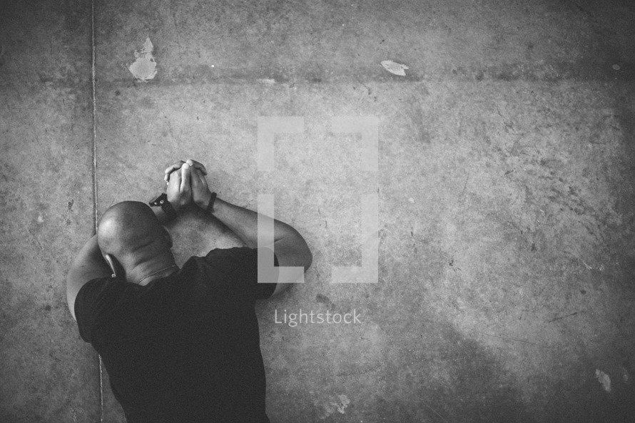Stock Photo Man lying face down on floor in prayer. by Pearl Lightstock